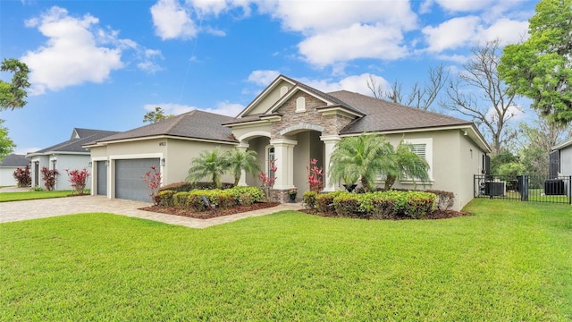 view of front facade with a front lawn, fence, stucco siding, decorative driveway, and stone siding