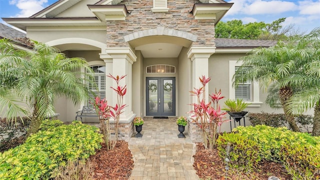 property entrance featuring french doors, stone siding, and stucco siding