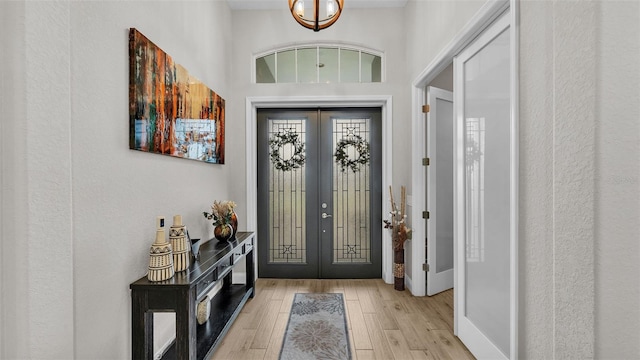 entryway featuring french doors, baseboards, and wood finished floors