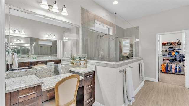 full bathroom featuring a shower stall, a spacious closet, and baseboards