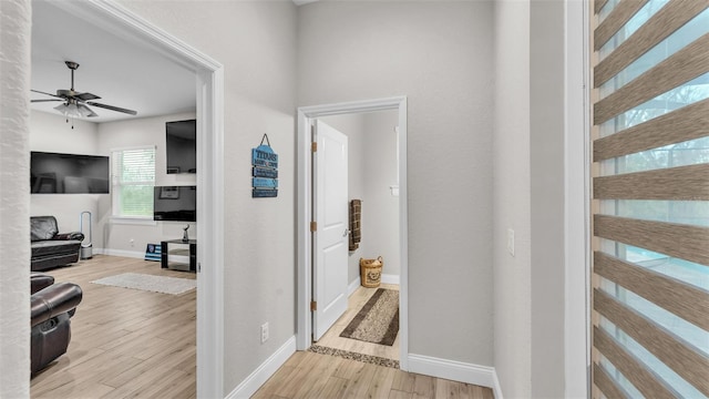 hallway with wood finished floors and baseboards