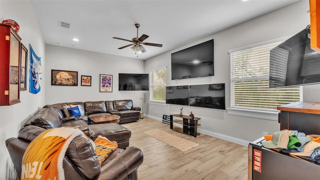 living area with visible vents, ceiling fan, baseboards, and light wood-style floors