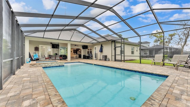 pool featuring glass enclosure, a patio, an in ground hot tub, and ceiling fan