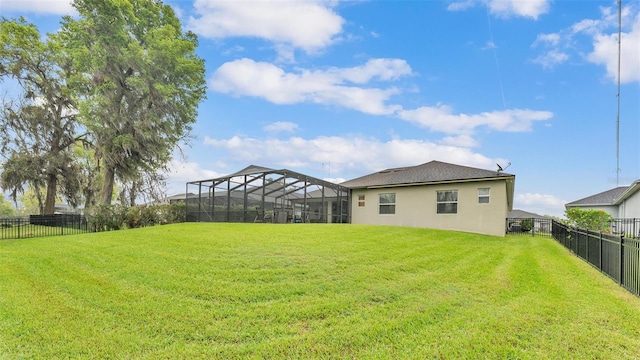 view of yard with glass enclosure and a fenced backyard