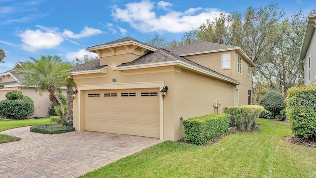 view of front of property featuring a garage, a shingled roof, decorative driveway, a front lawn, and stucco siding