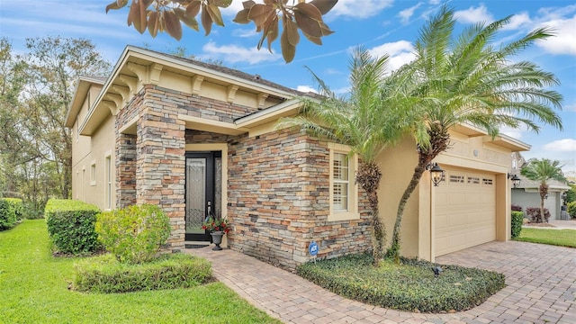 exterior space with stone siding, decorative driveway, an attached garage, and stucco siding