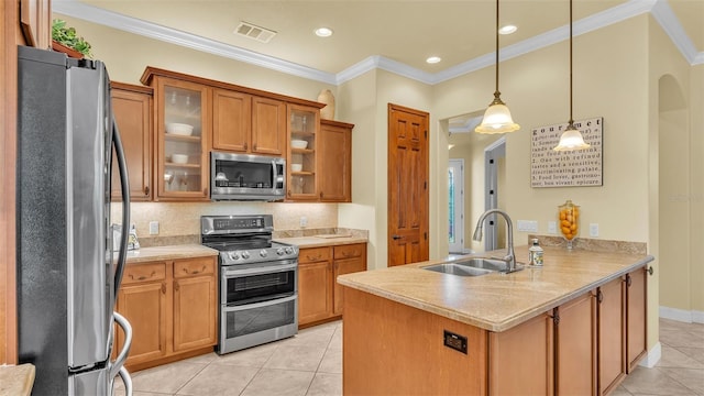 kitchen featuring arched walkways, brown cabinetry, stainless steel appliances, crown molding, and a sink