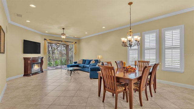 dining room with a glass covered fireplace, visible vents, crown molding, and light tile patterned floors