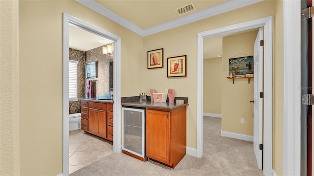 bar featuring light carpet, wine cooler, visible vents, and baseboards