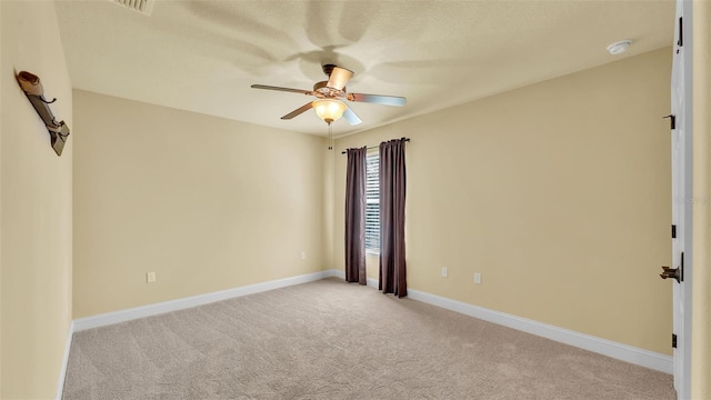 spare room with baseboards, a ceiling fan, and light colored carpet