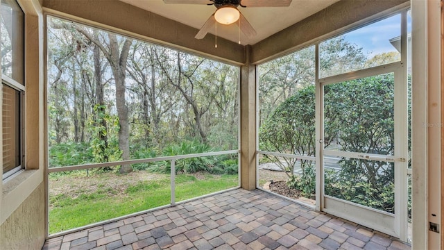 unfurnished sunroom with ceiling fan