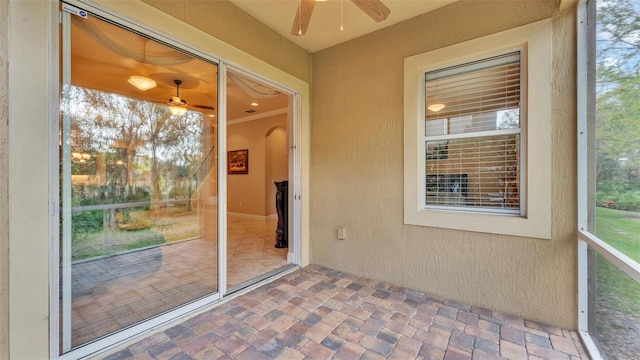 unfurnished sunroom featuring ceiling fan