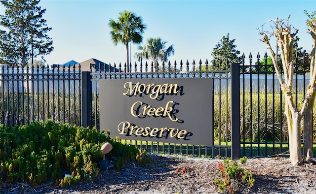 community / neighborhood sign with a water view and fence