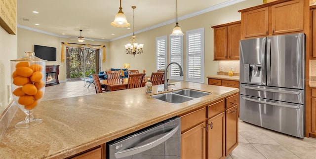 kitchen with light tile patterned floors, stainless steel appliances, a sink, brown cabinetry, and a glass covered fireplace