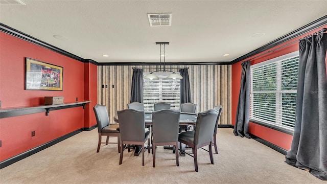 dining space featuring plenty of natural light, baseboards, visible vents, light colored carpet, and crown molding