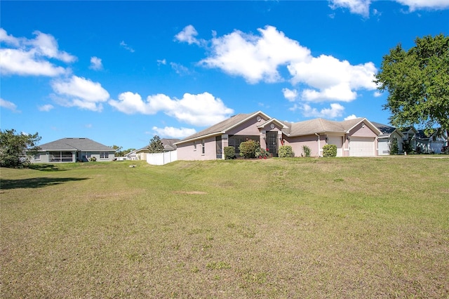 ranch-style house with a front yard, an attached garage, and stucco siding