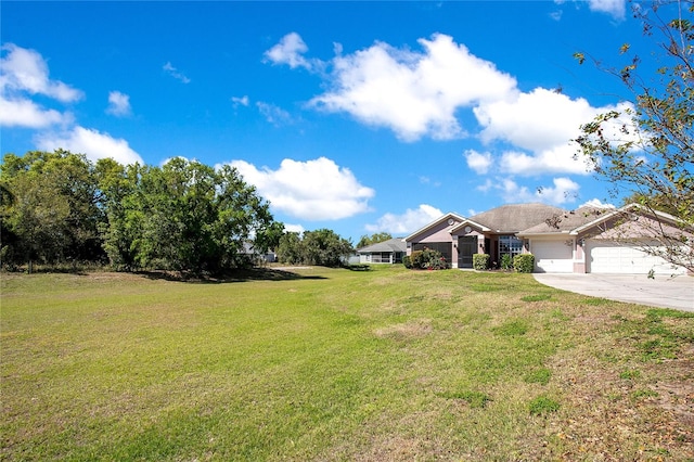 view of yard with an attached garage and driveway