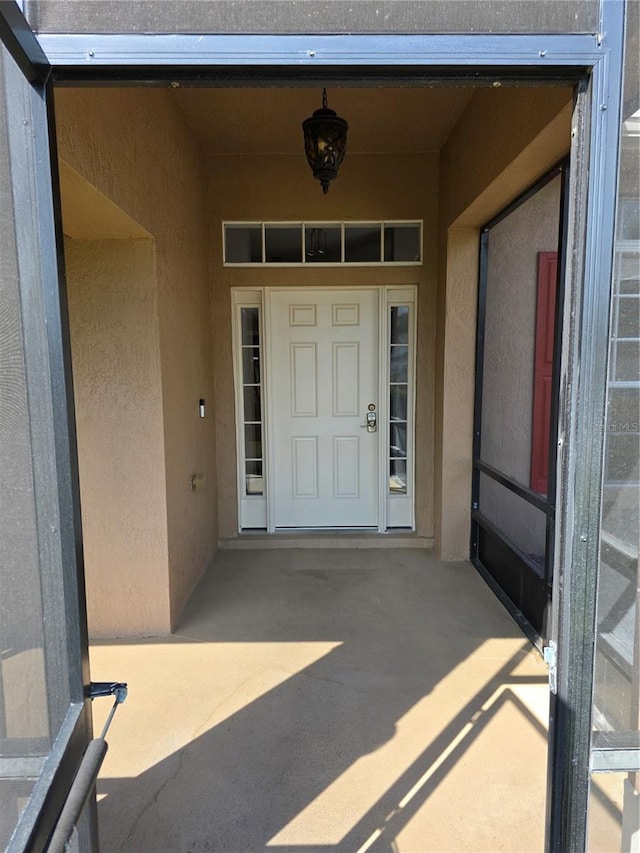 doorway to property featuring stucco siding