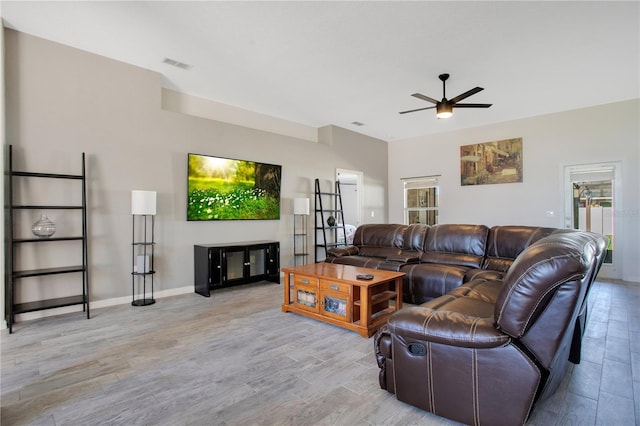 living room with light wood-style flooring, baseboards, visible vents, and ceiling fan