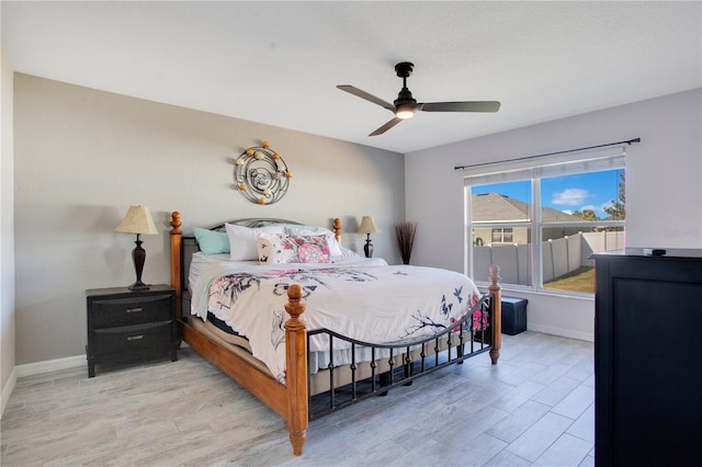 bedroom with light wood-style flooring, baseboards, and ceiling fan