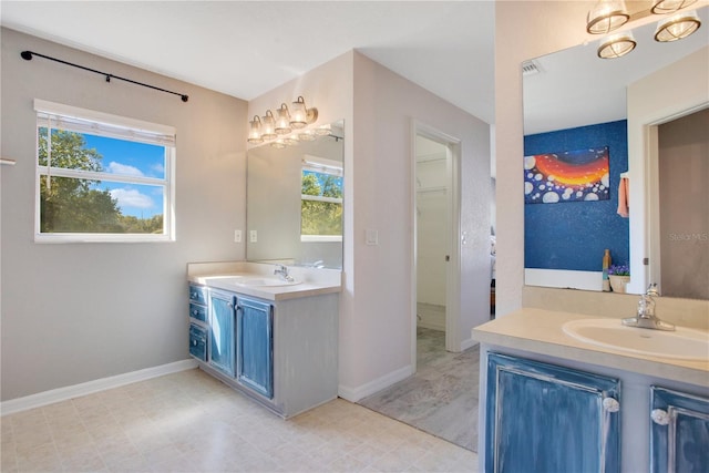 bathroom with tile patterned floors, visible vents, two vanities, a sink, and baseboards