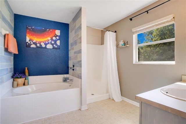 bathroom with a bath, a stall shower, vanity, and baseboards