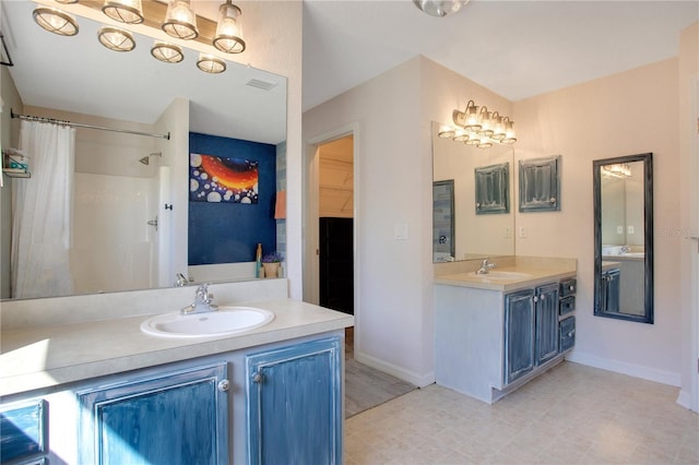 full bathroom with visible vents, two vanities, baseboards, and a sink