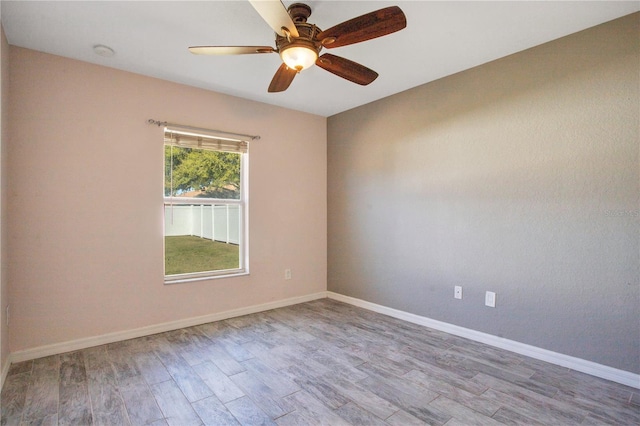 unfurnished room featuring ceiling fan, baseboards, and wood finished floors