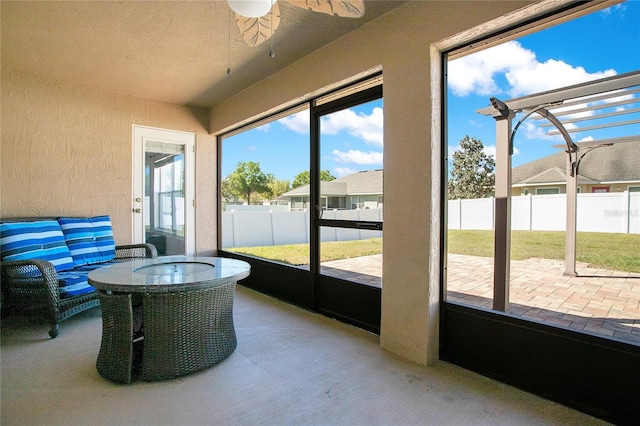 unfurnished sunroom featuring a ceiling fan