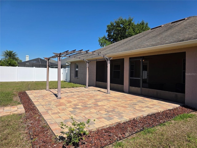 view of patio / terrace featuring a pergola, a sunroom, and fence