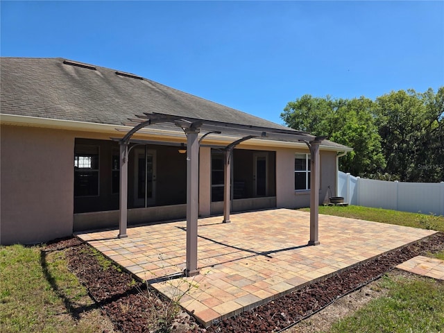 back of house featuring stucco siding, a patio, roof with shingles, and fence