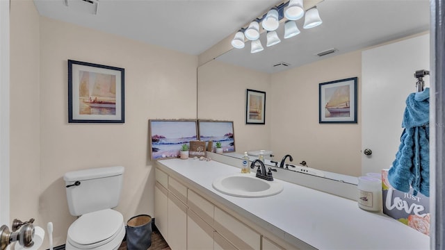 bathroom with visible vents, vanity, and toilet