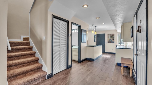 interior space featuring stairs, baseboards, wood finished floors, and recessed lighting