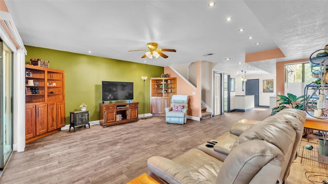 living area featuring recessed lighting, visible vents, baseboards, stairs, and light wood-type flooring