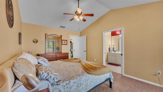 bedroom featuring lofted ceiling, light colored carpet, visible vents, ensuite bathroom, and baseboards