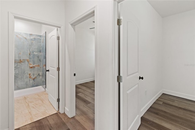 corridor with wood finished floors and baseboards