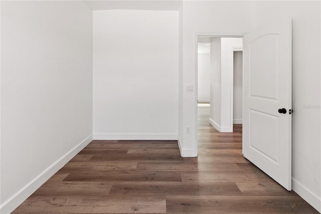 spare room featuring wood finished floors and baseboards