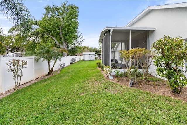 view of yard featuring a sunroom and a fenced backyard