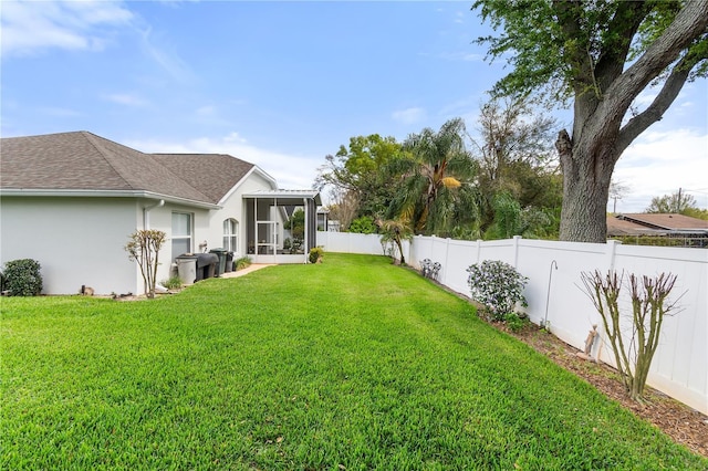 view of yard featuring a sunroom and a fenced backyard