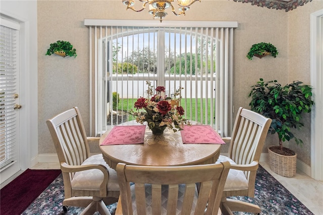 tiled dining room with baseboards and a notable chandelier