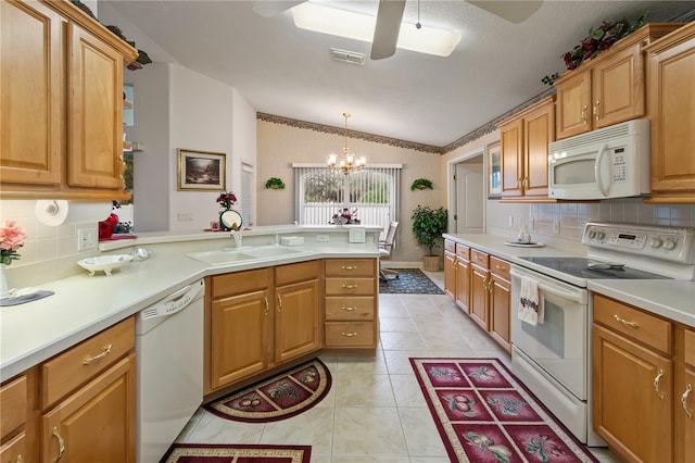 kitchen with light tile patterned floors, a peninsula, white appliances, a sink, and vaulted ceiling