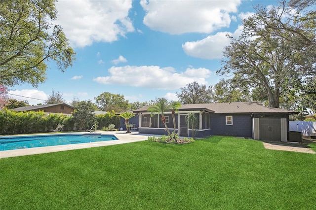 back of property featuring a sunroom, a fenced in pool, fence, and a lawn