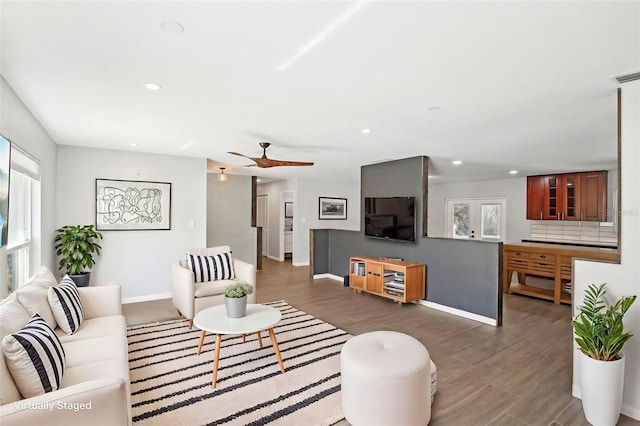 living room featuring baseboards, wood finished floors, and recessed lighting