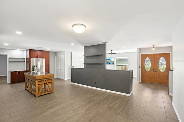 kitchen with open shelves, recessed lighting, stainless steel fridge with ice dispenser, wood finished floors, and baseboards