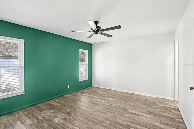 empty room featuring wood finished floors, a ceiling fan, and baseboards