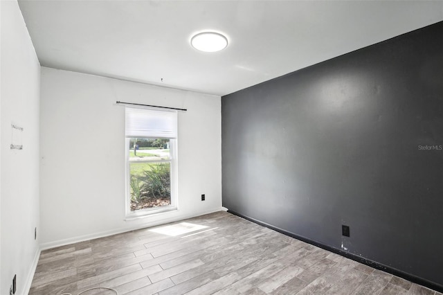 empty room with baseboards and wood finished floors