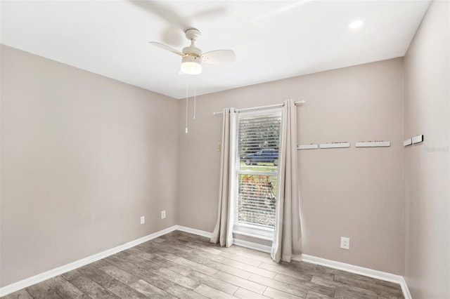 spare room with baseboards, a ceiling fan, and wood finished floors