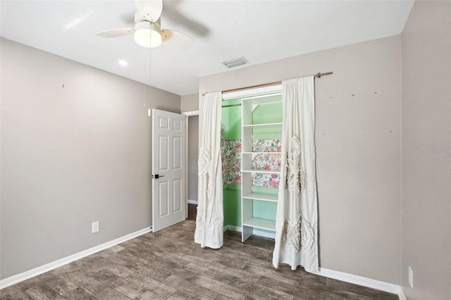 unfurnished bedroom featuring baseboards, visible vents, ceiling fan, and wood finished floors