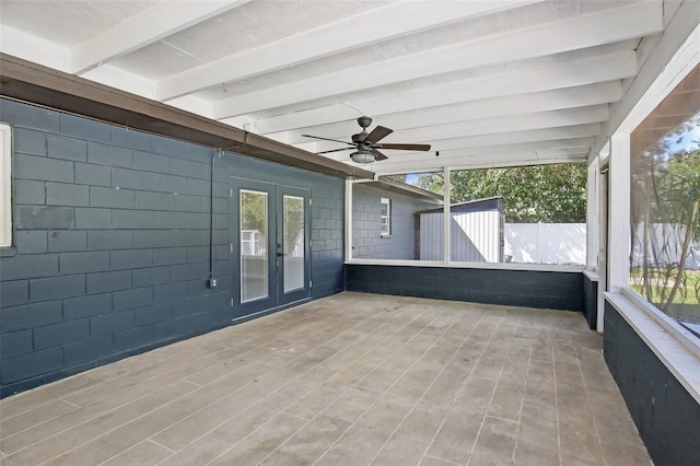 unfurnished sunroom featuring ceiling fan, french doors, and beamed ceiling