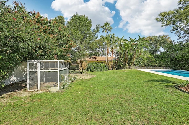 view of yard with an outbuilding, fence, exterior structure, and an outdoor pool